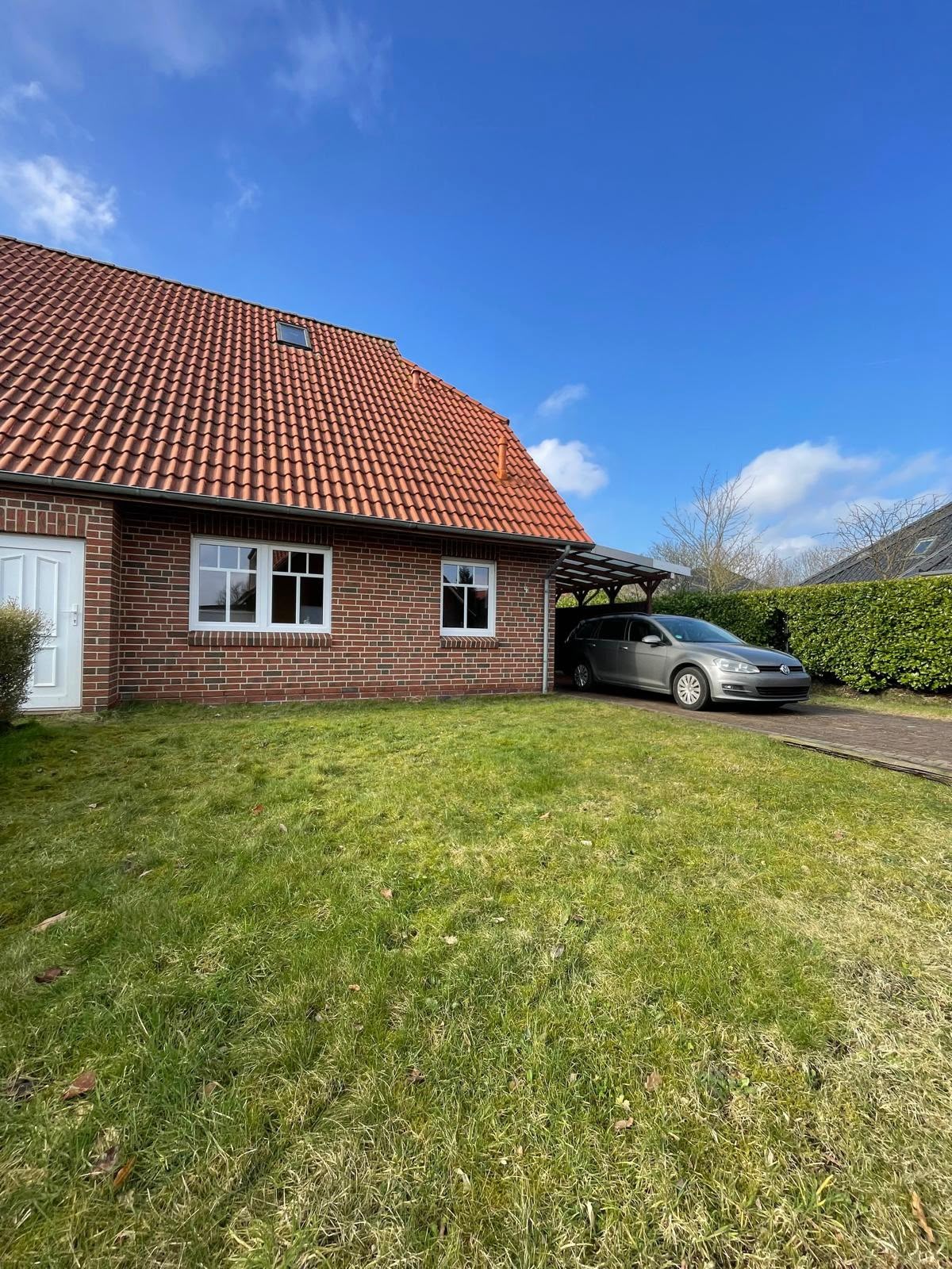Doppelhaushälfte in Marienhafe, Außenansicht mit Carport und Garten